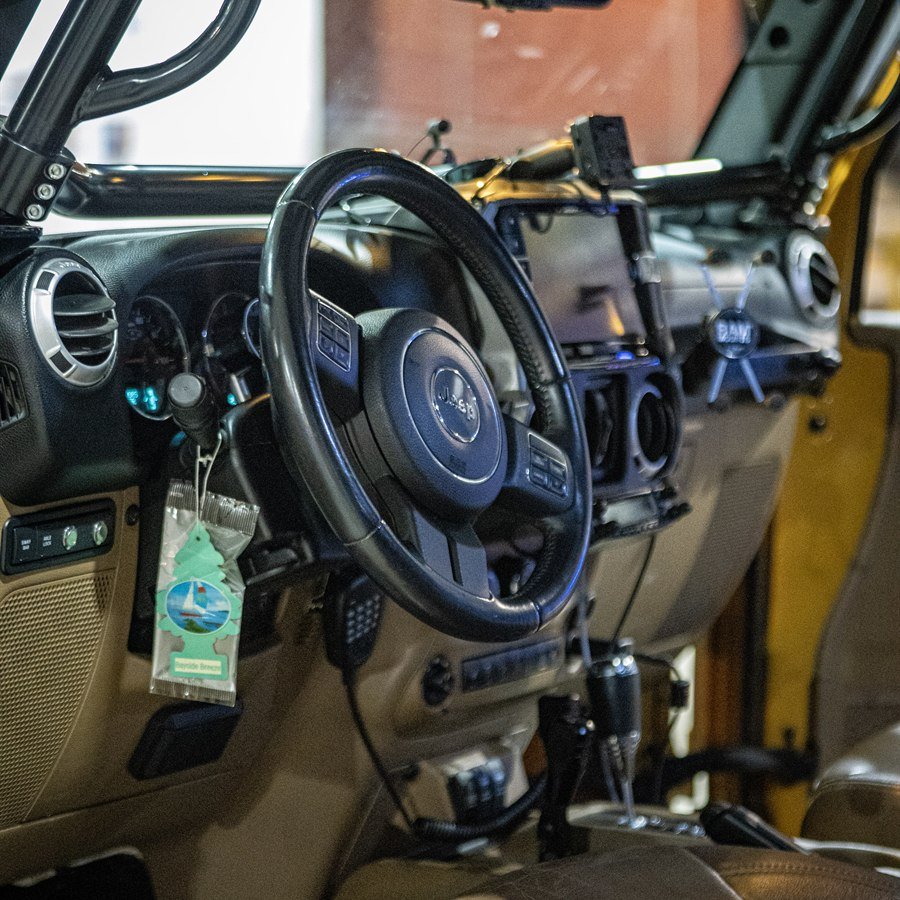 Cockpit interior with roll cage, Alpine head unit, and RAM mount